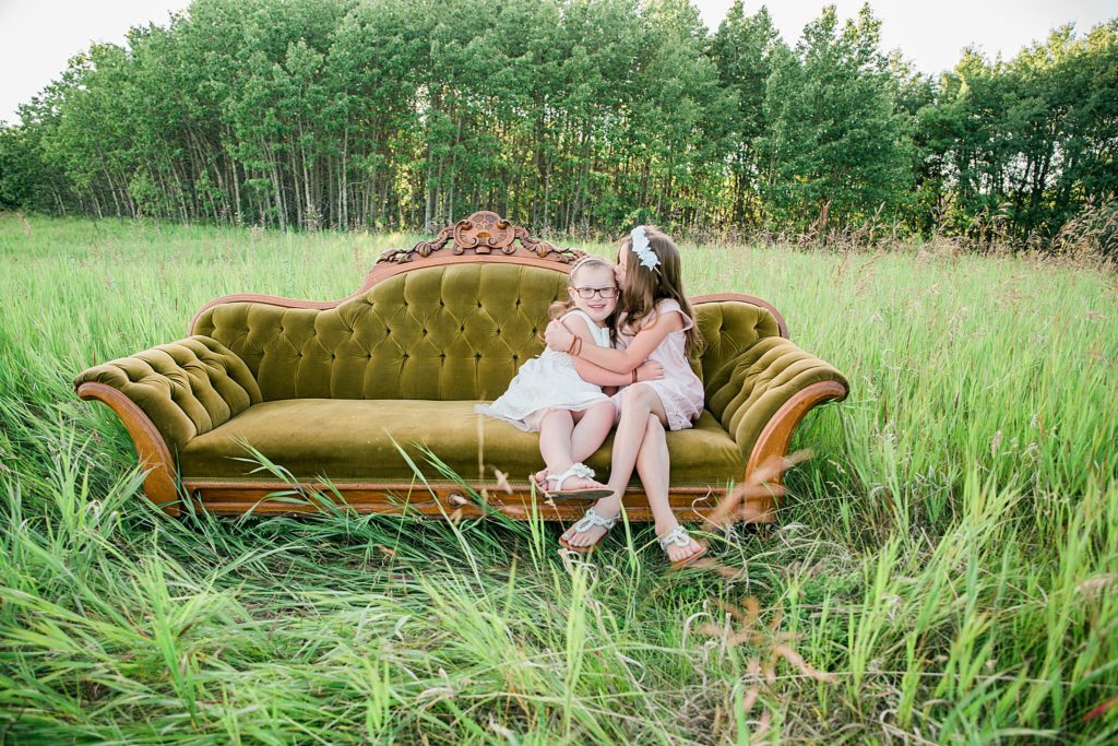 sisters, sofa in a field