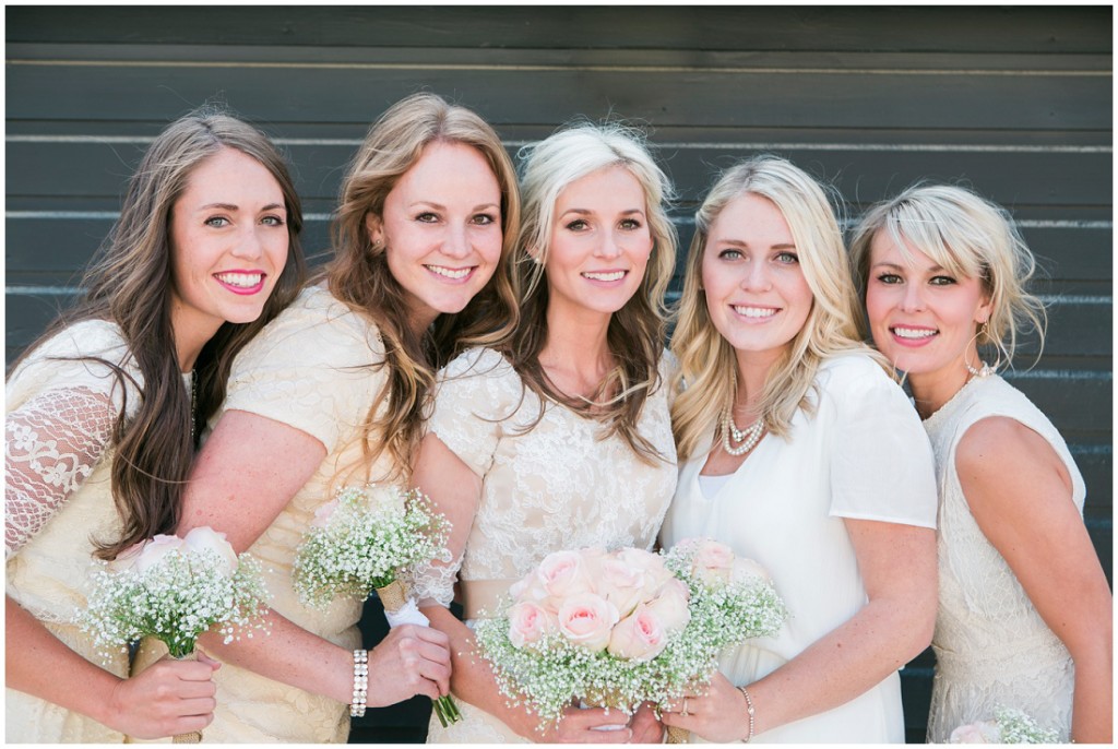Bride and bridesmaids all in cream with roses and baby's breath bouquets